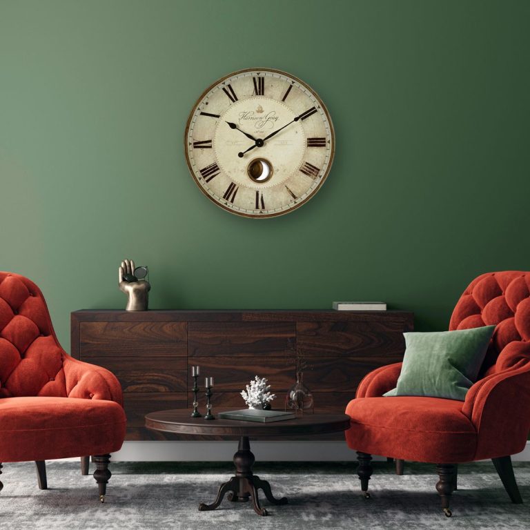 Living in stil minimalist - ceas rotund, perete verde, comoda din lemn, masuta rotunda din lemn, 2 fotolii caramizii, perna decorativa verde