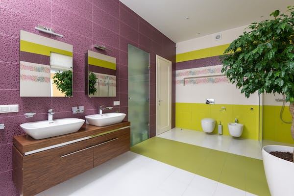 Amenajare baie de lux - Decoratiunile si utilitatile potrivite pentru o baie de lux_Baie de lux moderna, perete decorativ cu tonuri de mov, roz, verde deschis, chiuveta, vas de toaleta, planta decorativa